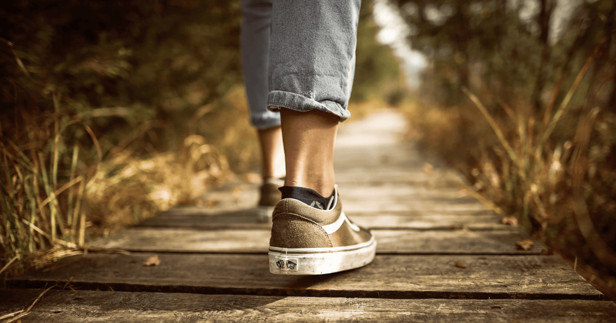 A pair of feet walking on a path.